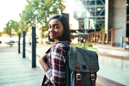 Teenage girl with backpack on smiling to the camera