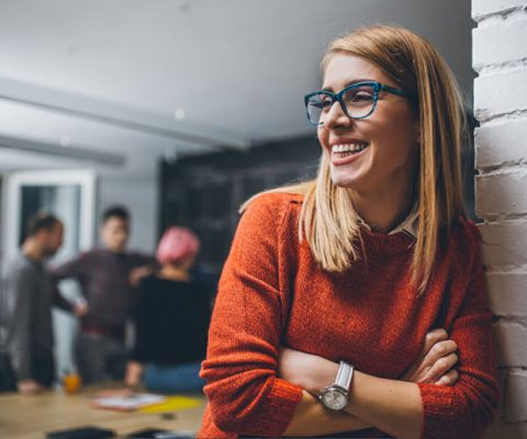 An image of a woman smiling and wearing glasses