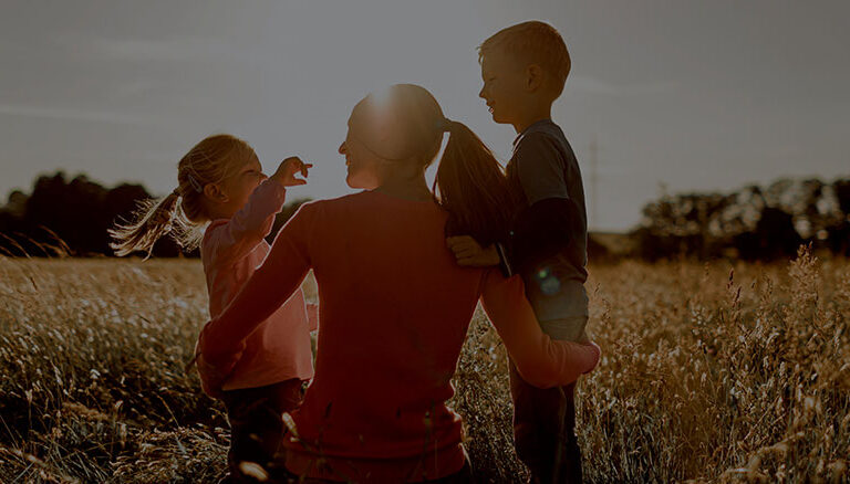 A mother with her two young children in a field