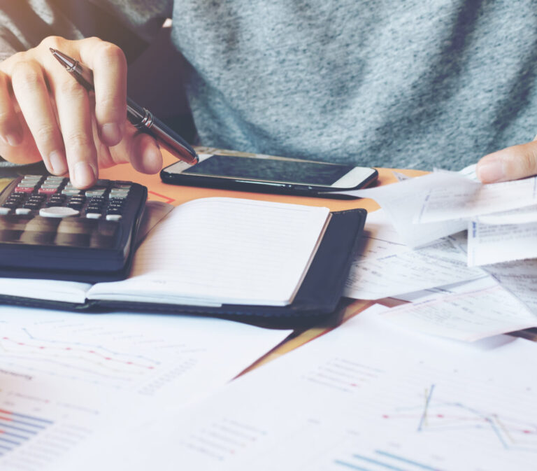 Person sitting at a desk using a calculator