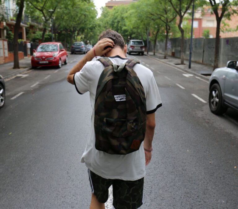 A teen boy walking down a street